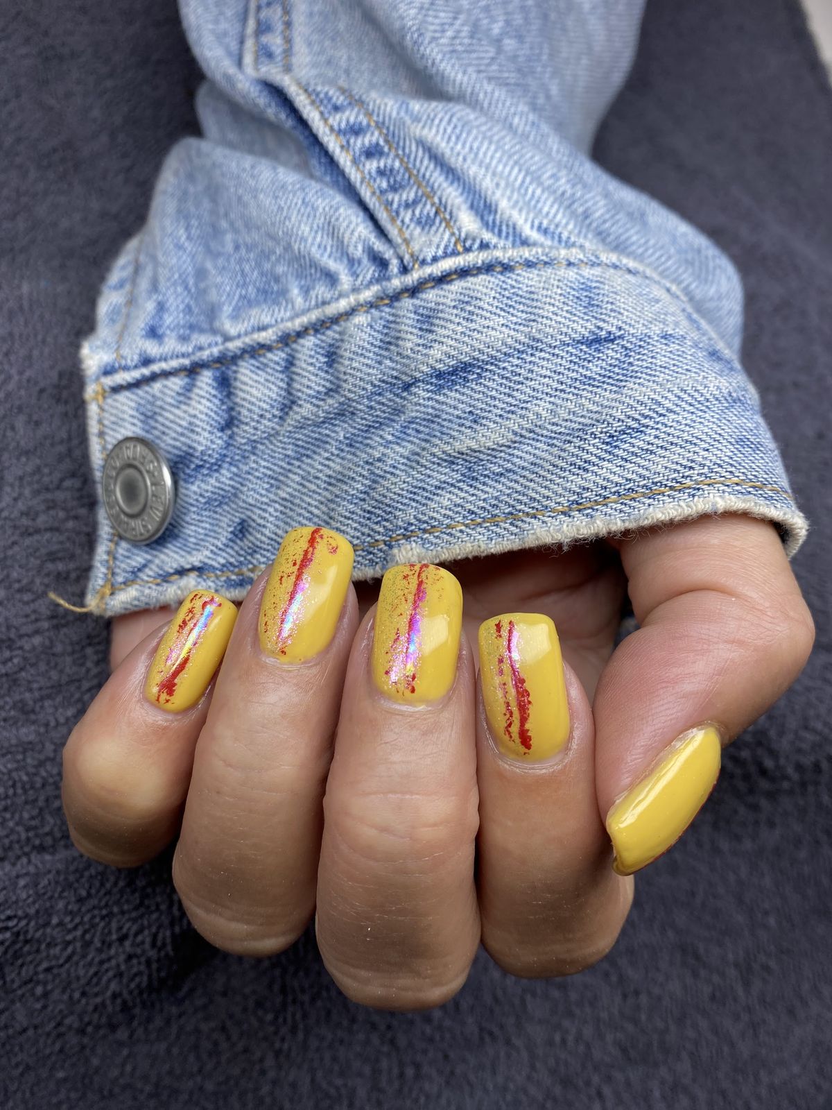 Gele nagels met rode en okerkleurige abstracte nail art