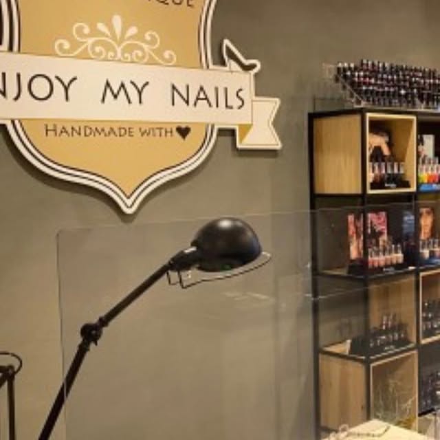 De nailboutique met het gouden Enjoy my Nails schild aan de wand